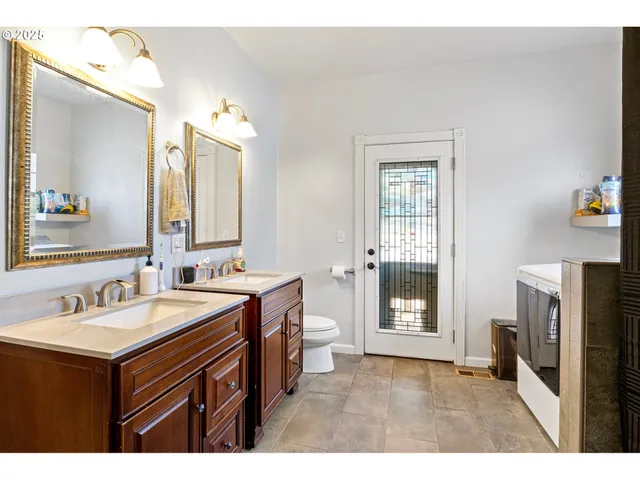 a bathroom with a sink a mirror a vanity and a toilet
