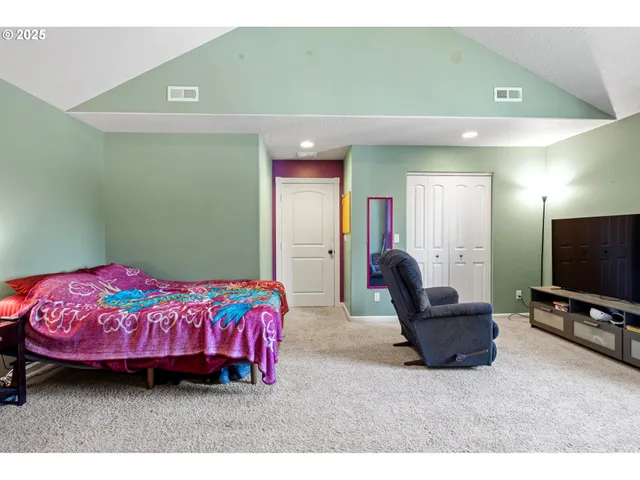 a bedroom with furniture and a flat screen tv