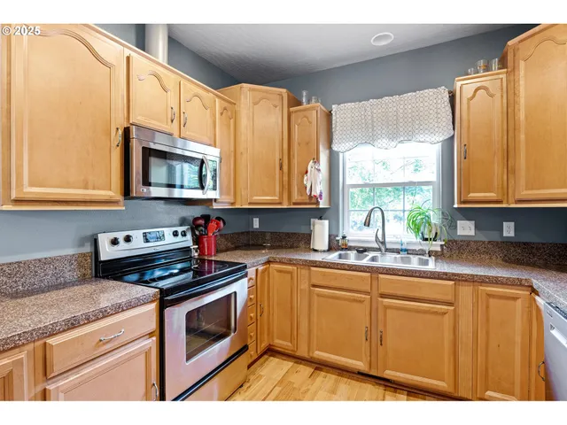 a kitchen with stainless steel appliances a stove a sink and a microwave