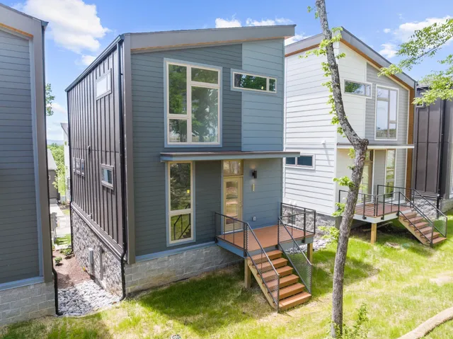 a view of house with a yard chairs and iron fence