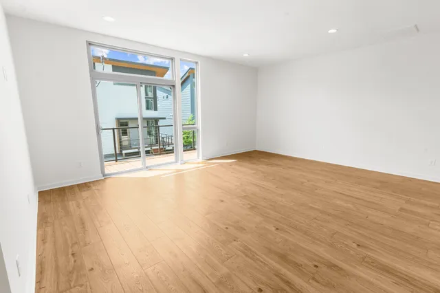 a view of an empty room with wooden floor