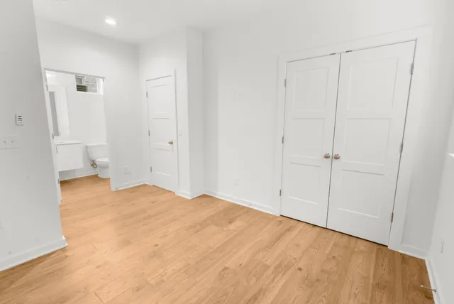 an empty room with a window and ceiling fan