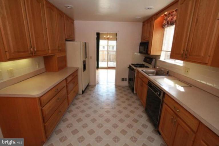 1313 Gresham Road Silver Spring, MD 20904 - Photo 5 of 28 a kitchen with a sink stove and cabinets