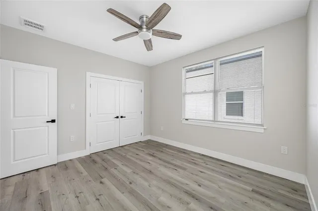 a view of a big room with wooden floor and windows
