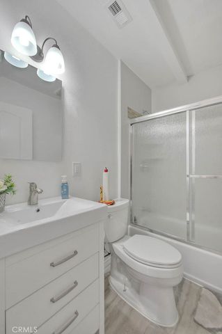 a bathroom with a toilet a sink a mirror and shower