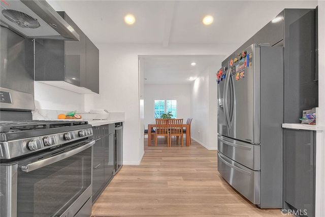 a kitchen with stainless steel appliances granite countertop a refrigerator stove and sink