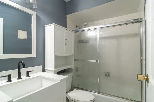 a bathroom with a sink toilet and shower