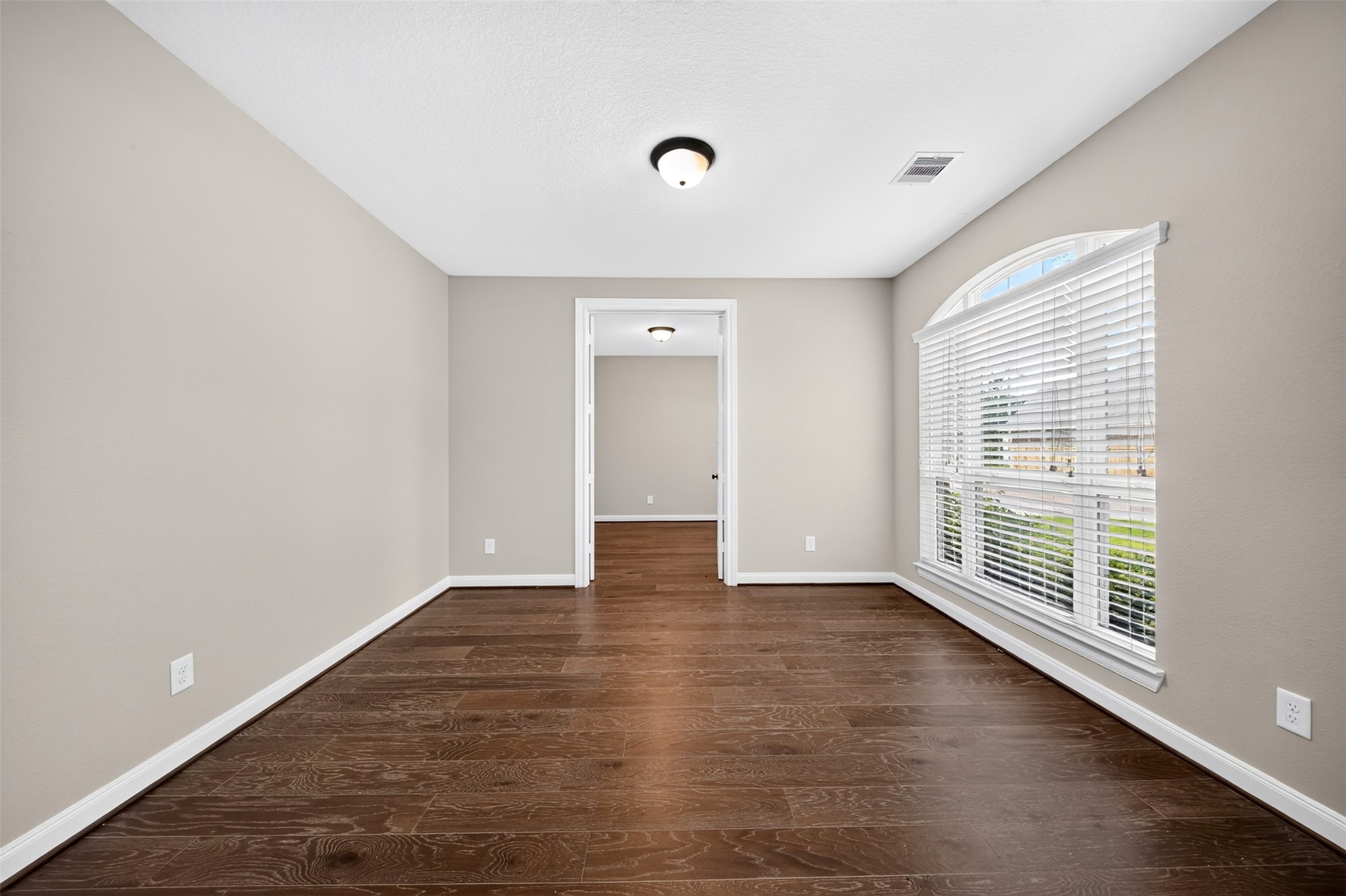 6234 Avon Landing Lane Spring, TX 77379 - Photo 8 of 49 The neutral toned walls and warm wood flooring create a calming atmosphere, while the architectural arched window adds a touch of class to the formal living room.