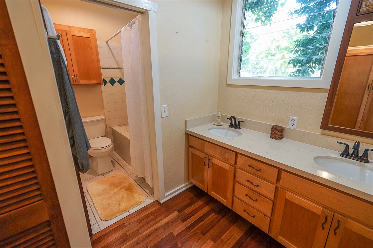 6410 Puupilo Road, Unit A1 Kapaa, HI 96746 - Photo 11 of 19 a bathroom with a double vanity sink and mirror with shower
