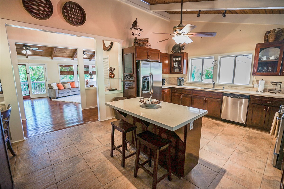 6410 Puupilo Road, Unit A1 Kapaa, HI 96746 - Photo 6 of 19 a kitchen with stainless steel appliances kitchen island granite countertop a table chairs in it and wooden floors
