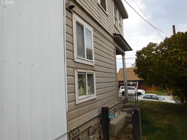 a patio with table and chairs and potted plants