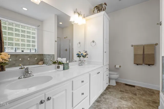 a bathroom with a double vanity sink mirror and toilet