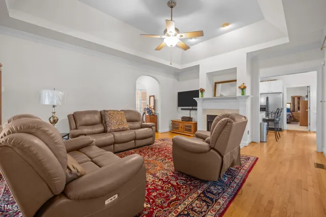 a living room with furniture a fireplace and a chandelier