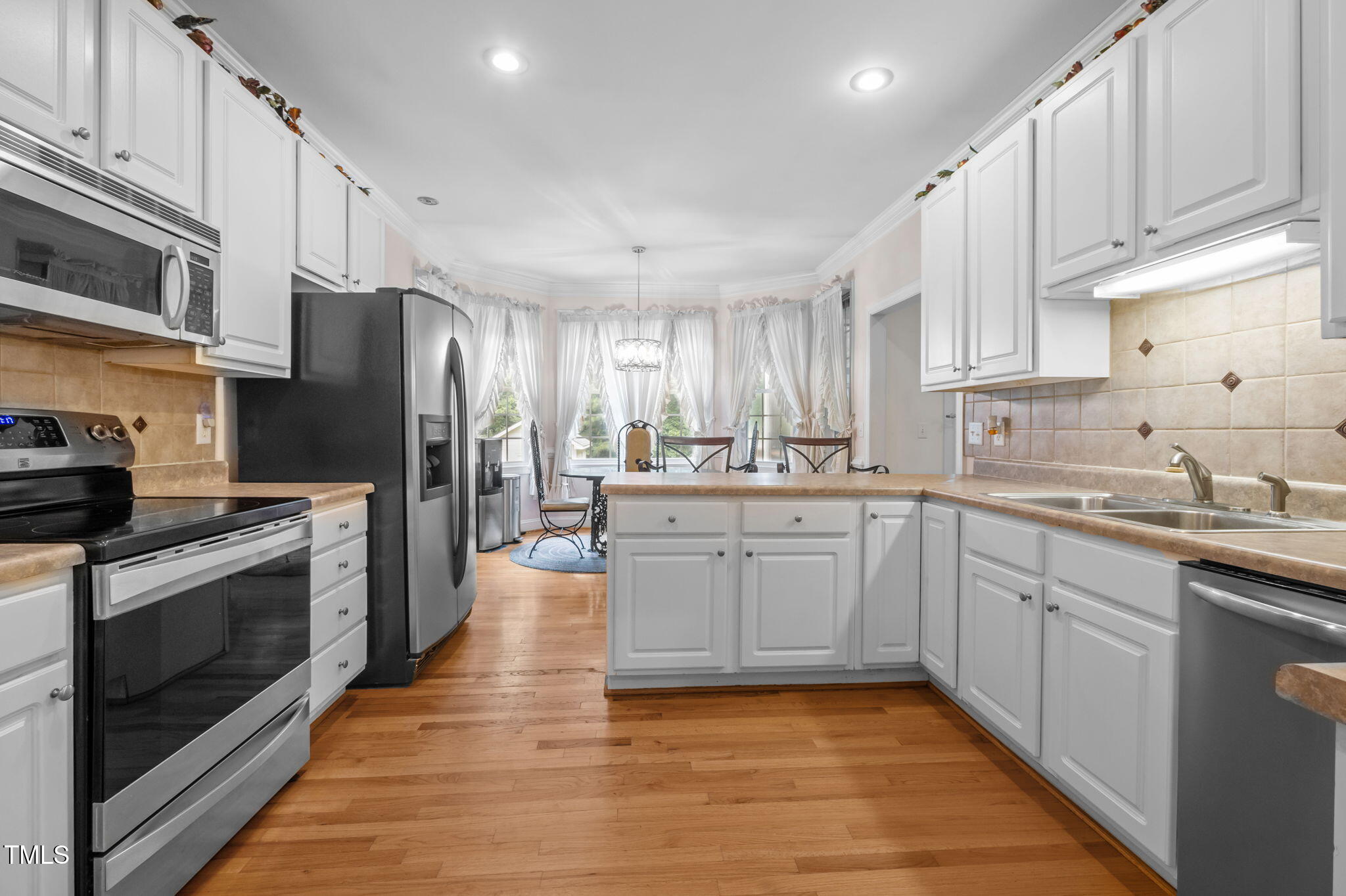 9 Piney Grove Road Bahama, NC 27503 - Photo 7 of 33 a kitchen with stainless steel appliances granite countertop a refrigerator oven a sink dishwasher and white cabinets with wooden floor