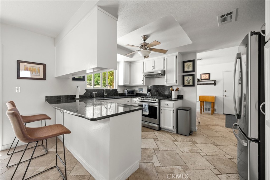 2532 Briar Glen Road Acton, CA 93510 - Photo 8 of 48 a kitchen with stainless steel appliances granite countertop a stove a sink a refrigerator a dining table and chairs