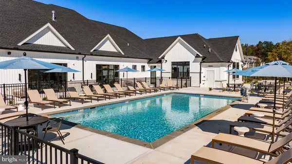 a view of a house with pool and chairs