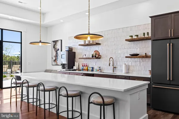 a kitchen with stainless steel appliances a sink a stove a refrigerator and cabinets