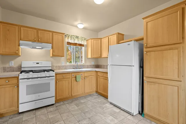 a kitchen with a refrigerator sink stove and cabinets