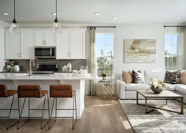 a living room with furniture a flat screen tv and kitchen view