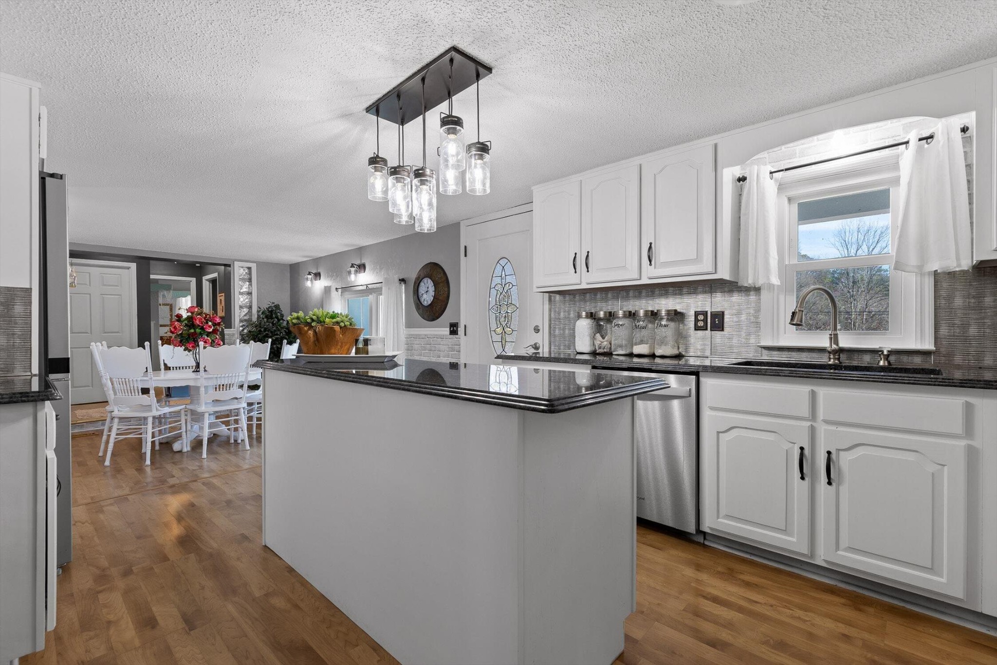 5017 McDonald Road McDonald, TN 37353 - Photo 11 of 52 a kitchen with stainless steel appliances granite countertop a stove top oven a sink a dining table and chairs with wooden floor