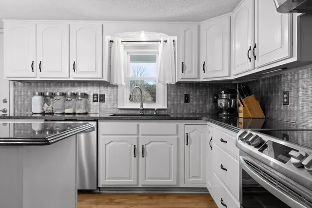 a kitchen with stainless steel appliances granite countertop a sink and cabinets