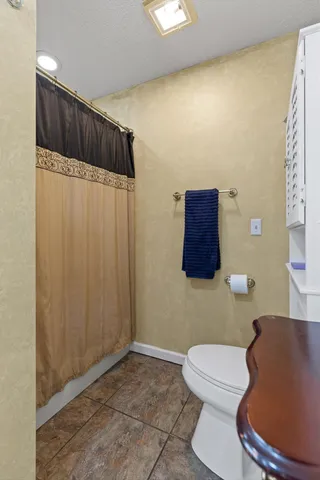 a bathroom with a toilet and a shower curtain