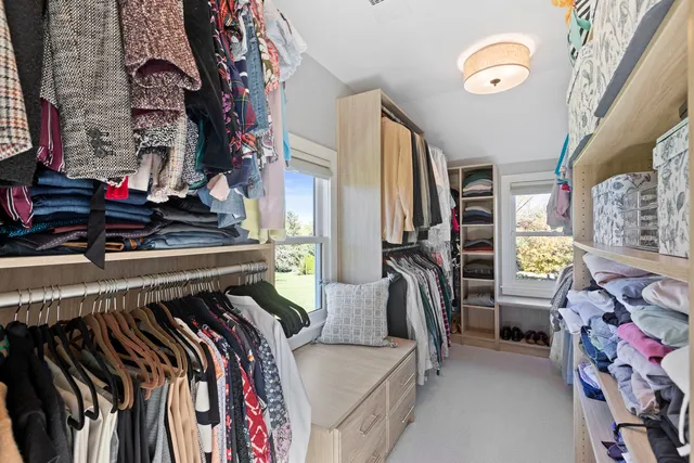 a view of walk in closet with clothes and shoes