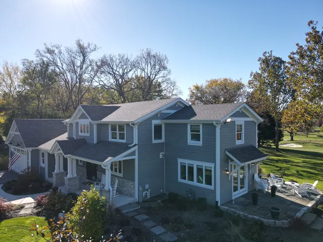 an aerial view of a house with garden space and lake view