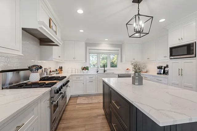 a kitchen with stainless steel appliances granite countertop a sink a stove and cabinets