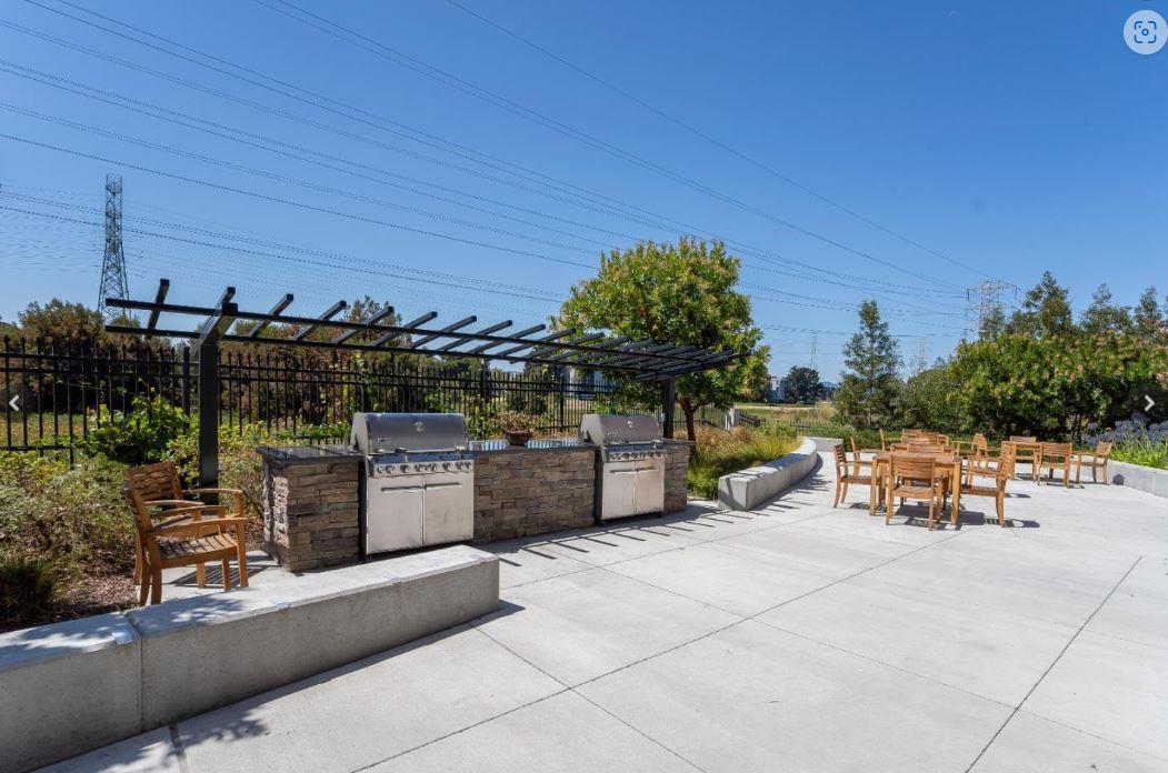 400 Mariners Island Boulevard, Unit 215 San Mateo, CA 94404 - Photo 19 of 29 a view of a patio with dining table and chairs with wooden fence