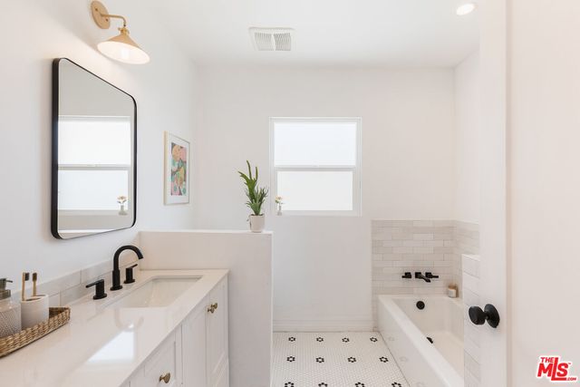 a bathroom with double vanity sinks and a mirror