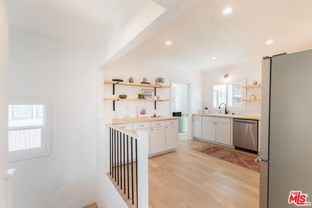 a kitchen with white cabinets and white appliances