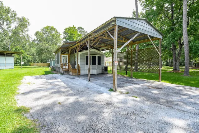 a view of a house with backyard and trees