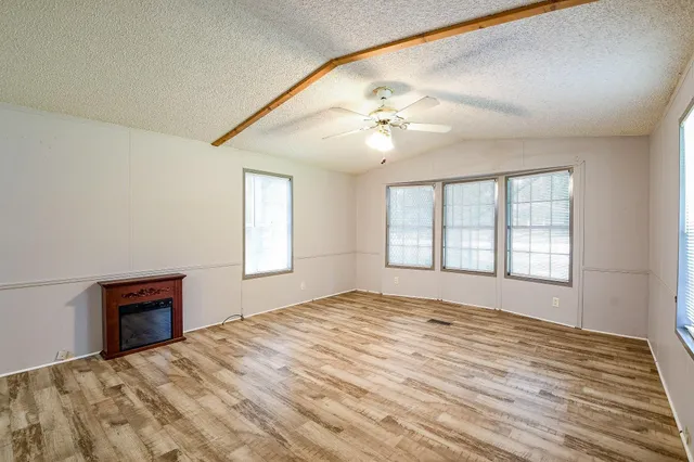 a view of empty room with window and ceiling fan