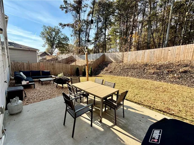 a view of a swimming pool with a patio and a yard