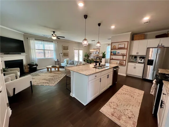 a kitchen with stainless steel appliances kitchen island granite countertop a sink stove and refrigerator