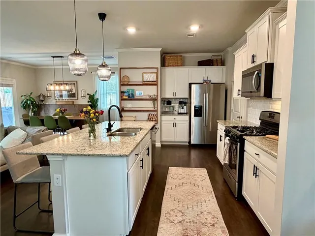a kitchen with a sink a counter space appliances and cabinets