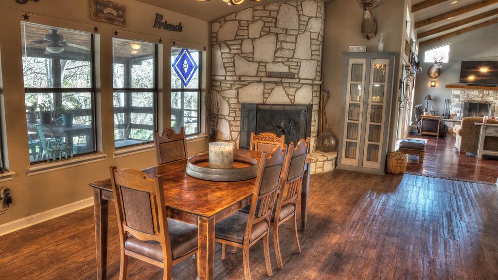 187 Roy Chisum Road Leakey, TX 78873 - Photo 21 of 40 a view of a dining room with furniture a chandelier and wooden floor