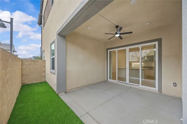 a view of an empty room with a window and a ceiling fan