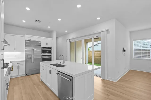 a kitchen that has a lot of cabinets in it and wooden floors