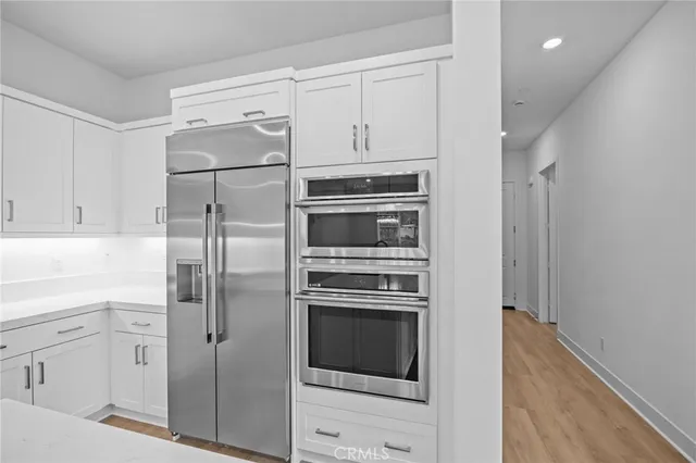 a kitchen with cabinets stainless steel appliances and counter space