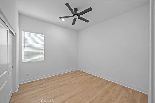 an empty room with a window and a fan