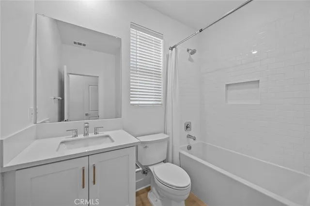 a bathroom with a sink toilet vanity and shower