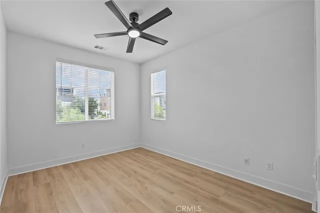 an empty room with a window and a ceiling fan
