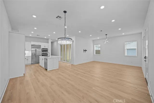 a view of kitchen with refrigerator stove and wooden floor