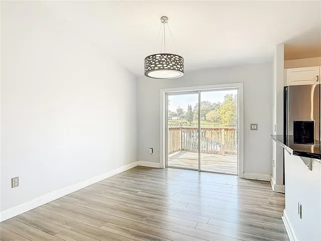 a view of a kitchen with a refrigerator and wooden floor