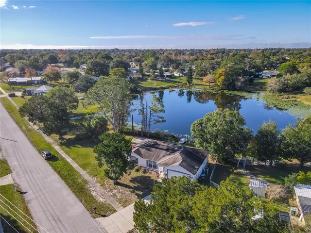 an aerial view of residential houses with outdoor space and lake view