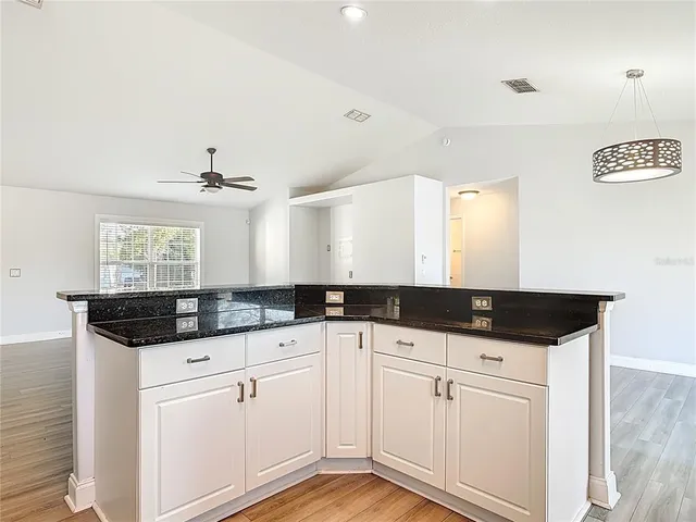 a kitchen with granite countertop a sink cabinets and stainless steel appliances
