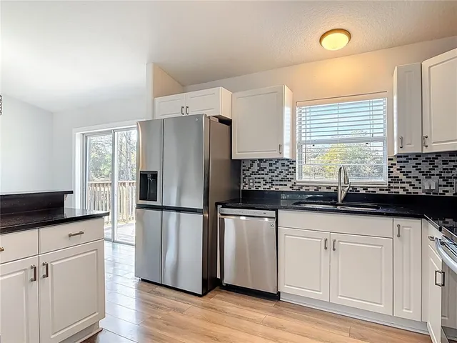 a kitchen with stainless steel appliances granite countertop a stove and cabinets