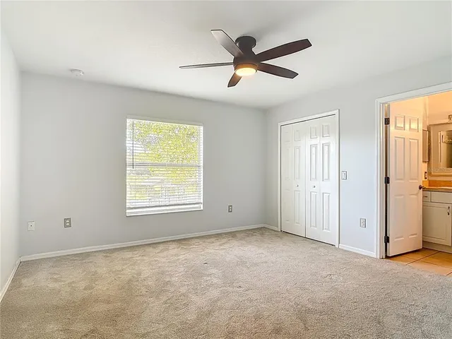 an empty room with a window and a fan